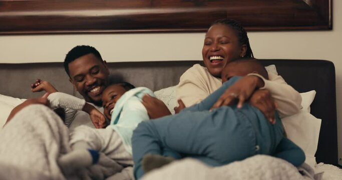 Black family, children and funny with parents in bed for playing or laughing in the morning together. Mother, father and kids in the bedroom for love, comedy or bonding while in their home to relax