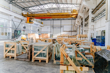 Interior of a large glass and mirror cutting factory. Sheet glass in pallets.