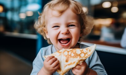 Young child eating a crepe on Shrove Tuesday, holding a mouth-watering pancake and laughing with delight, little greedy boy or girl with open mouth, smiling, thrilled and eager to taste the snack