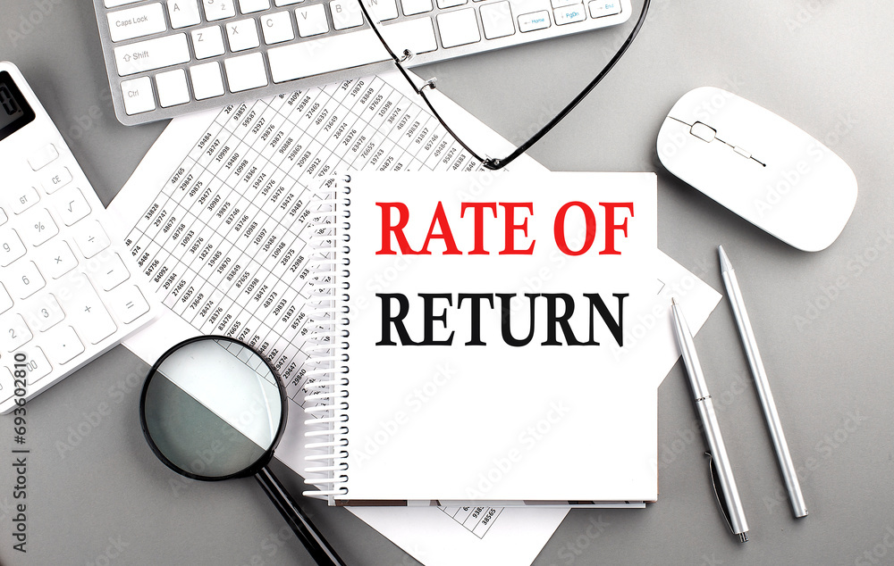 Poster rate of return text on notepad on chart with keyboard and calculator on grey background