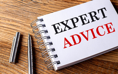 EXPERT ADVICE text on notebook with pen on wooden background