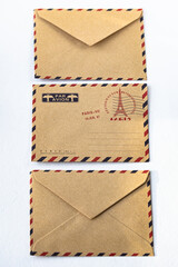 Three brown envelopes on white background, vertical. Airmail envelope. Letter to Paris