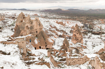 snow and volcanic cliffs with caves, Uchisar, Cappadocia, Turkey