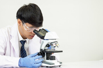 Portrait Asian man student scientist Wearing a doctor gown in the lab looking hand at chemist....
