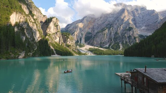 View over Lake Braies or Pragser Wildsee in the Dolomites, one of the most beautiful lakes in Italy. Boats in the middle of the lake surrounded by mountains. Travel and leisure.