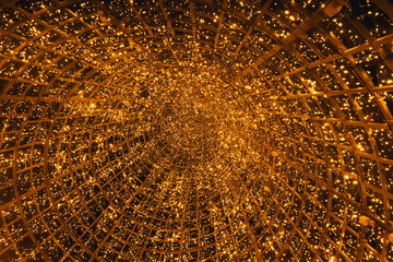 New Year's tree in the city of Lisbon. Christmas lights in Portugal. view inside the tree, orange and yellow glare garlands.
