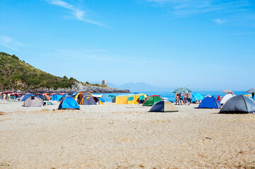 Young people camping in tents on the beach.