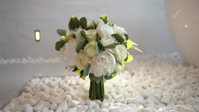 beautiful wedding bouquet of the bride of white roses and green eucalyptus close-up, romantic atmosphere before the outdoor ceremony, floristry and decoration