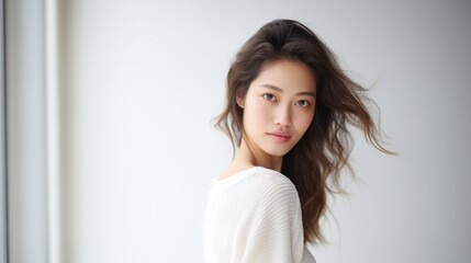 Gorgeous brunette Asian woman , clear glowing skin, perfect shiny body after spa effect, doing nourishing skincare routine, spa at home, standing over white background.