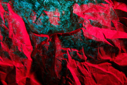 Papel tissu&eacute; de servilleta absorbente para la higiene de manos y del hogar arrugado con pliegues, iluminado con luz roja y azul, forma una superficie texturizada abstracta para fondos