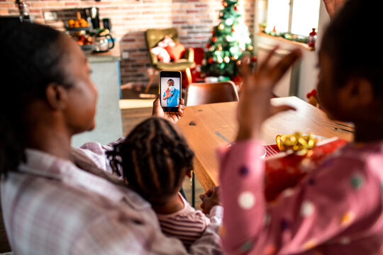 Family at home having video call with father at work