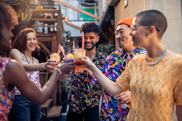 Multiracial group of happy friends drinking cocktails in bar