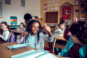 School children in classroom writing notes during class