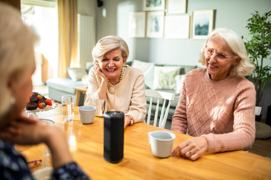 Senior women enjoying music on bluetooth speaker at home