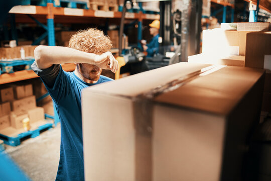 Tired young man working in warehouse