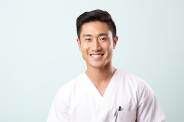 Charming Asian Male Nurse with a Smile - Isolated Image Showing Care, Health and Happiness with Copy Space on the Right - obrazy, fototapety, plakaty