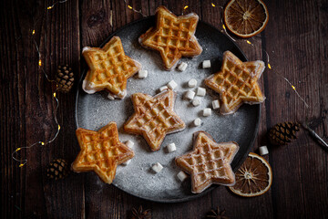 Belgian waffles with pine tree on background with Christmas light 