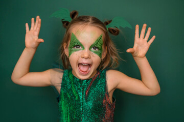 A girl in makeup, in the form of a dragon on a green background