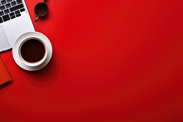 top view of a minimalist workspace featuring a sleek laptop and a cup of coffee on a vibrant red background, with free space for text or advertising