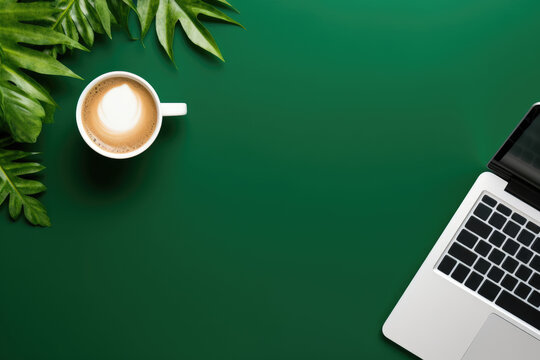 top view of a minimalist workspace featuring a sleek laptop and a cup of coffee on a vibrant green background, with free space for text or advertising