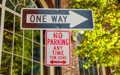 One-way arrow, urban symbol of directional flow and traffic control, against cityscape backdrop
