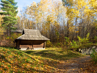 Wooden house with thatched roof. A small Traditional house in a mountain village. Picturesque village with small wooden house in autumn.