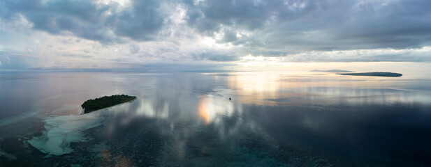 A serene sunrise illuminates the remote island of Koon near Seram, Indonesia. This scenic island's...