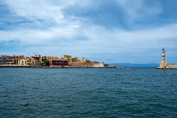Fototapeta na wymiar Crete Greece. Lighthouse, beacon at Venetian harbour in Old Town of Chania. Sunny day