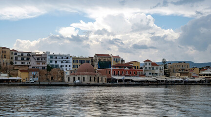 Chania Town Crete, Greece. Panoramic view of outdoors cafe, seaside building and church. Ripple sea.