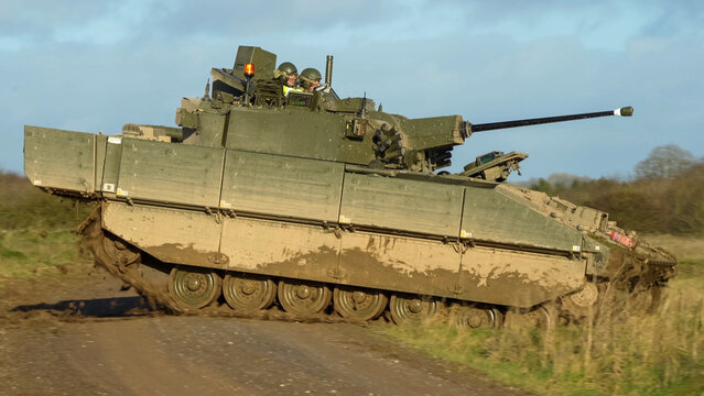 British army General Dynamics Ajax Reconnaissance and Strike armoured fighting vehicle (AFV), tank in action, crossing a track. Wilts UK