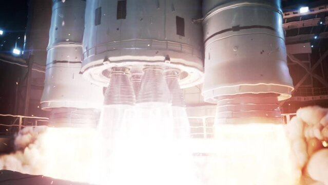 Vertical Takeoff of Large Rocket with Boosters. Space Exploration Rocket Launch at Night. Close-up shot of Rocket Engine Ignition. Powerful and Hot Flames Burst out of the Nozzle after Initial Impulse