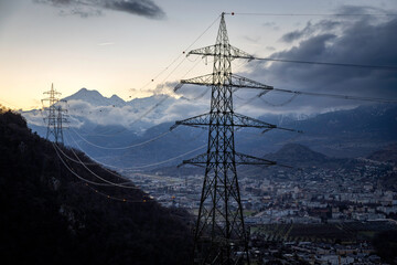 pylons of a high voltage line above the Rhône plain in Switzerland in winter - 693664006