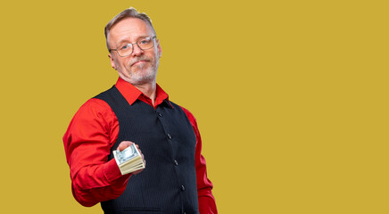 A Man Holding Money in a Red Shirt and Black Vest. A man in a red shirt and black vest holding money