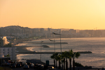 View of the city of Tangier, Ghandouri beach with the breakwaters, at sunset