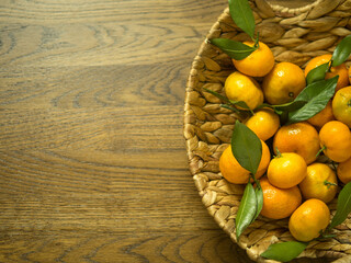sweet and ripe tangerines with leaves on a wooden table