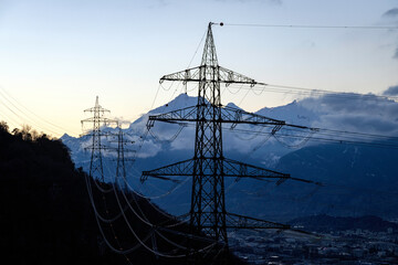pylons of a high voltage line above the Rhône plain in Switzerland in winter - 693666899