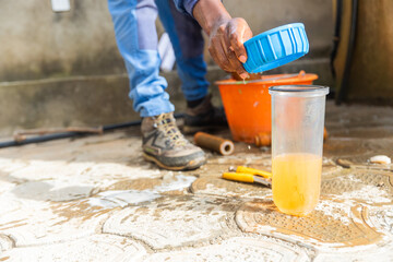 African plumber and a glass of rusty dirty water from a used water filtration cartridge