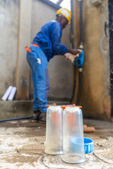 Vertical portrait of an African plumber cleaning the filtration system