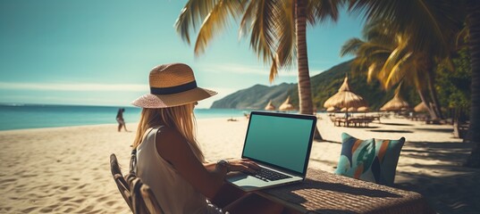 Young woman working on laptop computer by the beach  freelance work and travel concept