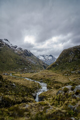 Fototapeta na wymiar Mountain river passing through a valley in New Zealand. This photo was taken on a hike on Routeburn track.