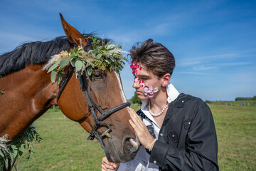 Jeune homme avec un cheval, tendresse avec des fleurs et des feuilles