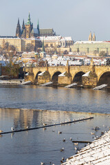 Snowy Prague Lesser Town with Prague Castle and Charles Bridge above River Vltava in the sunny Day , Czech republic