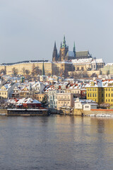 Snowy Prague Lesser Town with Prague Castle and Charles Bridge above River Vltava in the sunny Day , Czech republic