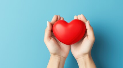 Hand holding a handmade red heart as a symbol of appreciation on blue background for International Nurses Day, celebrating healthcare heroes.