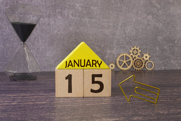 January 15 calendar date text on white wooden block with stationeries on wooden desk. Calendar date...