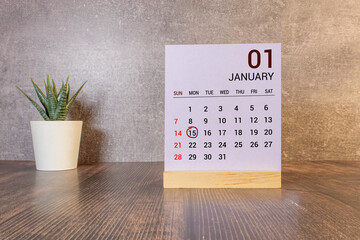 January 15 calendar date text on white wooden block with stationeries on wooden desk. Calendar date...