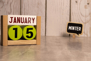 January 15 calendar date text on white wooden block with stationeries on wooden desk. Calendar date concept.