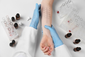 Doctor doing skin allergy test at light table, top view