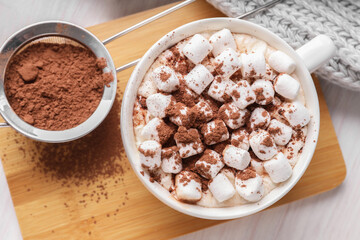 Cup of aromatic hot chocolate with marshmallows and cocoa powder on table, top view