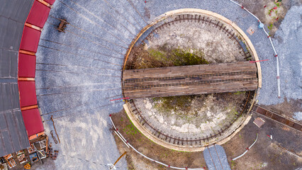 An Aerial Down View of a Narrow Gauge Train Yard, Turntable and Roundhouse, on a Sunny Spring Day